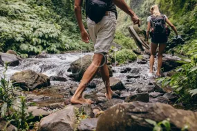 Couple crossing the stream barefooted